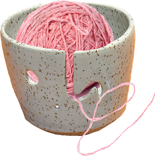 Ceramic bowl holding a ball of pink yarn